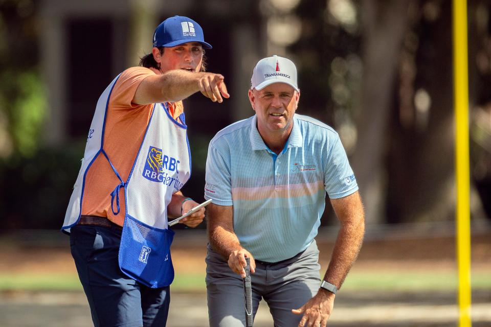 Stewart Cink , right, and his caddie and son Reagan Cink, left, plan his shot on the seventh green during the final round of the RBC Heritage golf tournament in Hilton Head Island, S.C., Sunday, April 18, 2021. (AP Photo/Stephen B. Morton)