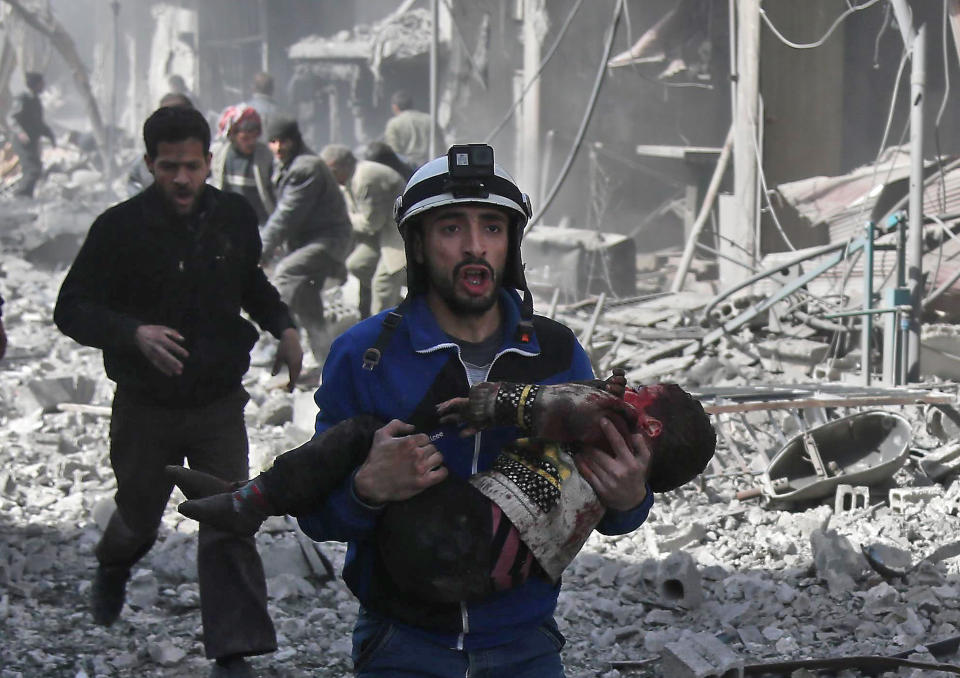 A Syrian civil defense member carries an injured child&nbsp;after a&nbsp;government bombing in the rebel-held town of Hamouria in Syria's besieged eastern Ghouta region. (Photo: ABDULMONAM EASSA via Getty Images)