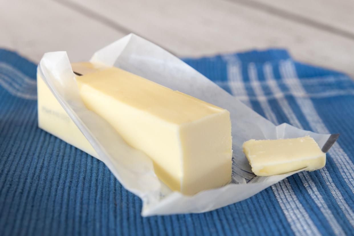 Stick of unwrapped butter on blue cloth