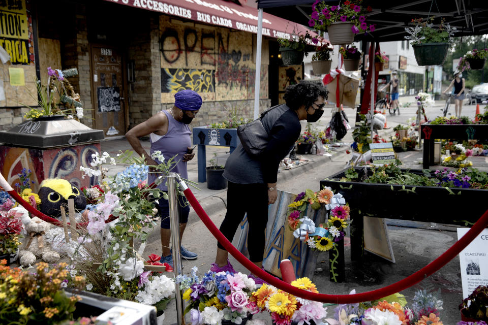 Elaine Davis and her mother Mildred stand over his memorial site in Minneapolis on Aug. 25, 2020. Elaine came from Atlanta to visit her mother and to pay her respects to George Floyd. (Ed Ou / NBC News)