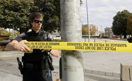 A police officer closes off the scene near the Canada War Memorial following a shooting incident in Ottawa October 22, 2014. REUTERS/Chris Wattie