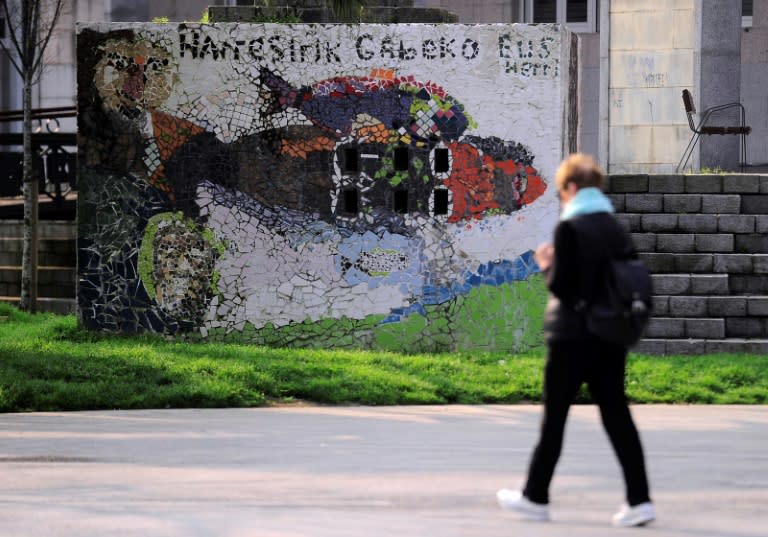 A woman walks past a graffiti reading in Basque "We want a Basque Country whitout walls", referring to Basque prisoners, in the Spanish northern village of Renteria on April 6, 2017