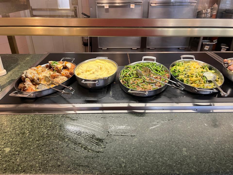 Buffet plates with chicken, mashed potatoes, green beans, and cheese-covered broccoli.