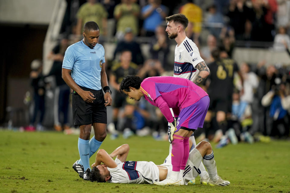 Vancouver Whitecaps defender Ranko Veselinovic lies on the pitch, next to goalkeeper Yohei Takaoka and defender Tristan Blackmon during the second half of the team's MLS playoff soccer match against Los Angeles FC on Saturday, Oct. 28, 2023, in Los Angeles. (AP Photo/Ryan Sun)