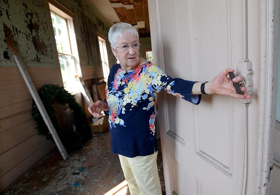 Mary McCarthly of the Friends of Saxonville checks out a door handle in the upper level of the Athenaeum Hall in Framingham.