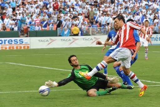 El tiro del paraguayo Edgar Benítez (D) es desviado por el golero de Guatemala Ricardo Jerez durante amistoso de cara a las eliminatorias mundialistas, el 15 de agosto de 2012, en Washington. El duelo acabó 3-3. (AFP | nicholas kamm)