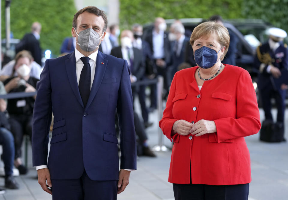 German Chancellor Angela Merkel, right, welcomes the President of France, Emmanuel Macron, left, for a meeting at the chancellery in Berlin, Germany, Friday, June 18, 2021. (AP Photo/Michael Sohn)