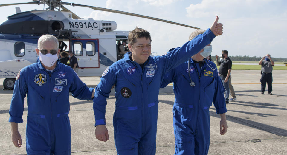 NASA astronaut Robert Behnken gives a thumbs up to onlookers as he boards a plane at Naval Air Station Pensacola to return him and NASA astronaut Douglas Hurley home to Houston a few hours after the duo landed in their SpaceX Crew Dragon Endeavour spacecraft off the coast of Pensacola, Fla., Sunday, Aug. 2, 2020. The Demo-2 test flight for NASA's Commercial Crew Program was the first to deliver astronauts to the International Space Station and return them safely to Earth onboard a commercially built and operated spacecraft. Behnken and Hurley returned after spending 64 days in space. (Bill Ingalls/NASA via AP)