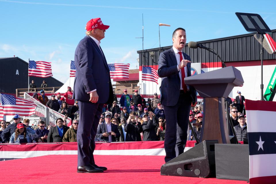 Republican presidential candidate and former President Donald Trump, left, listens as Senate candidate Bernie Moreno speaks at a campaign rally Saturday, March 16, 2024, in Vandalia, Ohio.