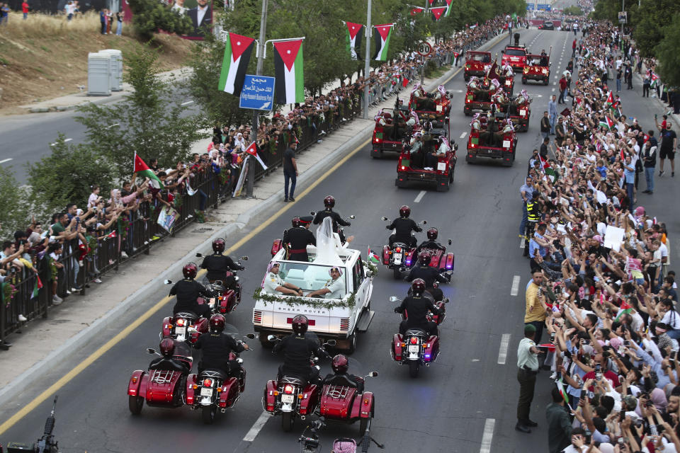 Jordan's Crown Prince Hussein and Saudi Rajqa Alseif wave to well-wishers during their wedding ceremonies in Amman, Jordan, Thursday, June 1, 2023. (AP Photo/Raad Adayleh)