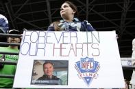 Angela Gott, of Toppenish, Wash., holds a sign dedicated to Steve Sabol during warmups before an NFL football game between the Green Bay Packers and the Seattle Seahawks, Monday, Sept. 24, 2012, in Seattle. Sabol, the president of NFL Films, died from brain cancer on Tuesday, Sept. 18, 18 months after he was diagnosed with a tumor on the left side of his brain. (AP Photo/Ted S. Warren)