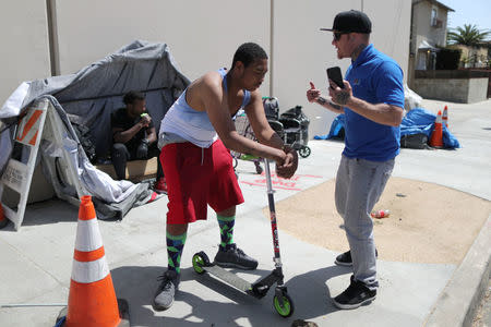 PATH Housing Outreach Case Manager Kris Toriz (R) raps with a homeless man he is helping, in Hollywood, Los Angeles, California, U.S. April 13, 2018. Picture taken April 13, 2018. REUTERS/Lucy Nicholson