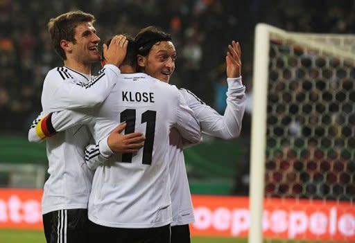 L-R: Germany's midfielder Thomas Mueller, striker Miroslav Klose and midfielder Mesut Oezil celebrate during the friendly match of Germany vs the Netherlands in preparation of the Euro 2012 in Hamburg, northern Germany. Germany won 3-0