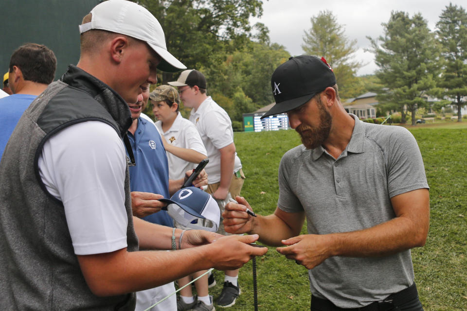 Kevin Chappell, right, gives autographs to fans after the ninth hole during the second round of A Military Tribute at The Greenbrier golf tournament in White Sulphur Springs, W.Va., Friday, Sept. 13, 2019. (AP Photo/Steve Helber)