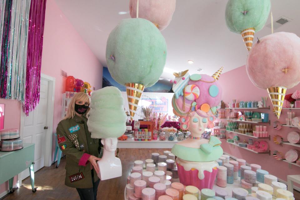 Spun Sugar Shoppe owner Mandy Tamborini holds a favorite decoration inside her Green Oak Township business Friday, Sept. 11, 2020.