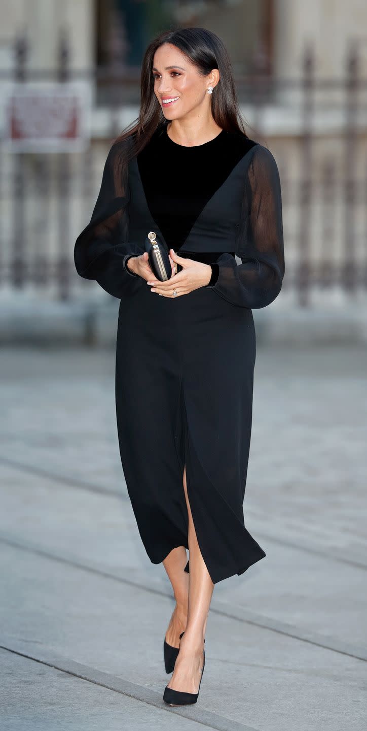 <p>For her first-ever solo outing, Meghan opted for one of her favourite designers, and floored us in this black Givenchy dress with sheer sleeves and fitted velvet bodice. Keeping her accessories simple, the Duchess went for matching black heels and clutch.</p>