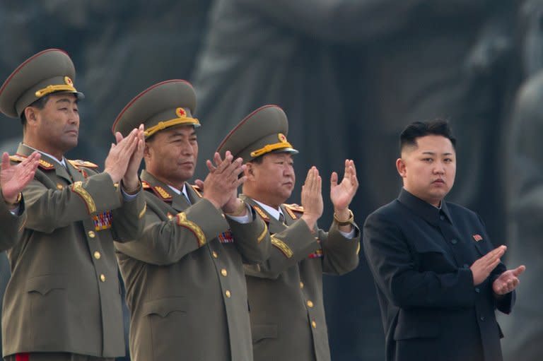 North Korean leader Kim Jong-Un (R) claps during the unveiling ceremony of two statues of former leaders Kim Il-Sung and Kim Jong-Il in Pyongyang on April 13, 2012. North Korea on Wednesday restored its official hotline with South Korea and announced it would let the South's businessmen visit a shuttered joint industrial zone, Seoul officials said