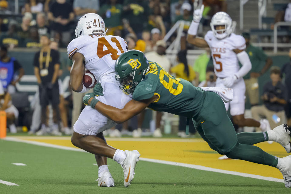 Texas linebacker Jaylan Ford (41) is brought down by Baylor wide receiver Micah Gifford after making an interception during the second half of an NCAA college football game Saturday, Sept. 23, 2023, in Waco, Texas. (AP Photo/Gareth Patterson)