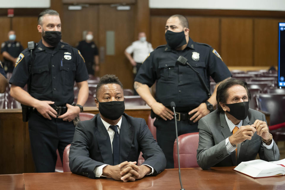 Actor Cuba Gooding Jr., center, sits at the defense table with his lawyer Marc Heller, during a hearing in his sexual misconduct case, Thursday, Aug. 13, 2020, in New York. A judge ordered the courtroom outfitted with Plexiglas and other measures to prevent the spread of the coronavirus, which has delayed the trial indefinitely. (Steven Hirsch/New York Post via AP, Pool)