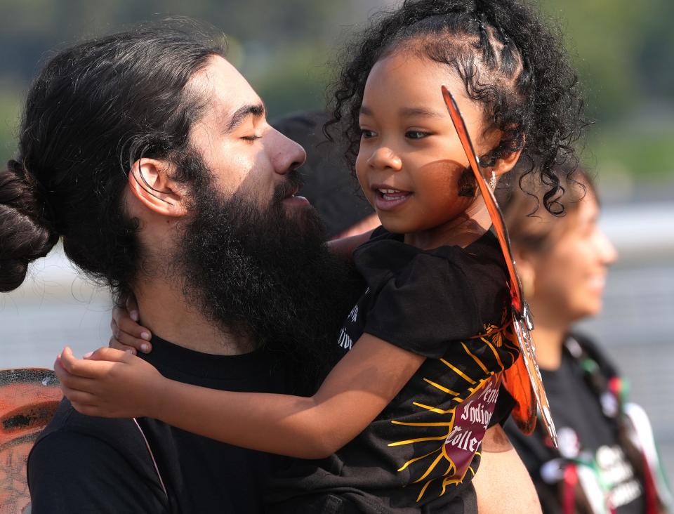 Eric Serrano holds Nova Smith, 4, as they prepare to walk with the Gente Indigena Collective, a group of Indigenous creatives and artists, Saturday before the start of the first Columbus Latine/Hispanic Heritage Month parade. The wings they were wearing represent the "Dreamers" community.