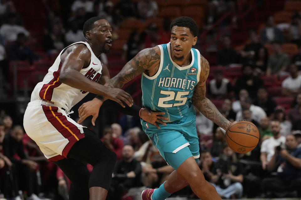 Charlotte Hornets forward P.J. Washington (25) dribbles the ball as Miami Heat center Bam Adebayo (13) defends during the first half of an NBA preseason basketball game, Tuesday, Oct. 10, 2023, in Miami. (AP Photo/Marta Lavandier)