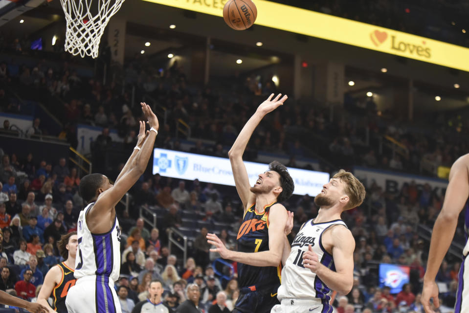 Oklahoma City Thunder forward Chet Holmgren, center, shoots over Sacramento Kings guard De'Aaron Fox, left, and forward Domantas Sabonis, right, in the second half of an NBA basketball game, Sunday, Feb. 11, 2024, in Oklahoma City. (AP Photo/Kyle Phillips)