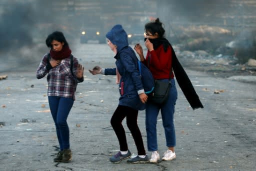 Palestinian demonstrators stand amidst smoke during clashes with Israeli troops in Ramallah, near the Jewish settlement of Beit El, in the occupied West Bank