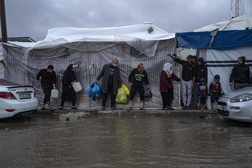 Palestinos desplazados por los bombardeos israelíes en la Franja de Gaza se ponen a cubierto de las lluvias invernales en un campamento de Naciones Unidas en la ciudad sureña de Jan Yunis, el 19 de noviembre de 2023. (AP Foto/Fatima Shbair)