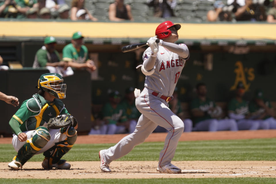 Los Angeles Angels' Shohei Ohtani hits a home run in the second inning of a baseball game Wednesday, June 16, 2021, in Oakland, Calif. Looking on is Athletics catcher Aramis Garcia. (AP Photo/Eric Risberg)