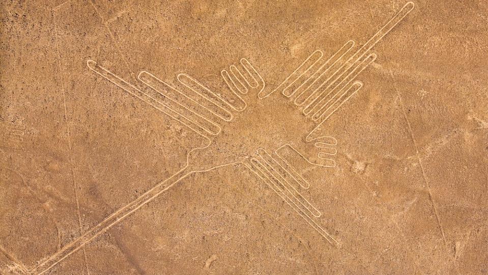 Aerial photo of Nazca lines in Peru. This geoglyph looks like a line drawing of a hermit bird (very similar to a hummingbird).