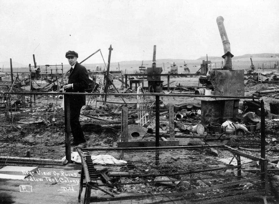 This 1914 photo provided by the Denver Public Library, Western History Collection, shows a man standing among the remains of a fire in Ludlow, Colo. April 20th marks the 100th anniversary of the Ludlow Massacre where 11 children and 2 women died in the fire set during a fight between striking coal miners and the Colorado National Guard. (AP Photo/Denver Public Library, Western History Collection)