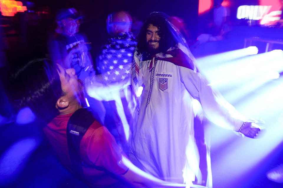 People dance during an official U.S. Soccer fan party at the Budweiser World Club ahead of a FIFA World Cup group B soccer match between the United States and Wales, in Doha, Sunday, Nov. 20, 2022. (AP Photo/Ashley Landis)