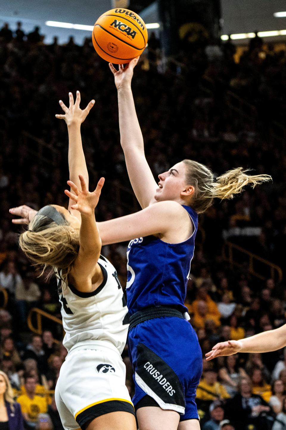 Holy Cross guard Bronagh Power-Cassidy attempts a basket against Iowa guard Gabbie Marshall, left, during Saturday's game.