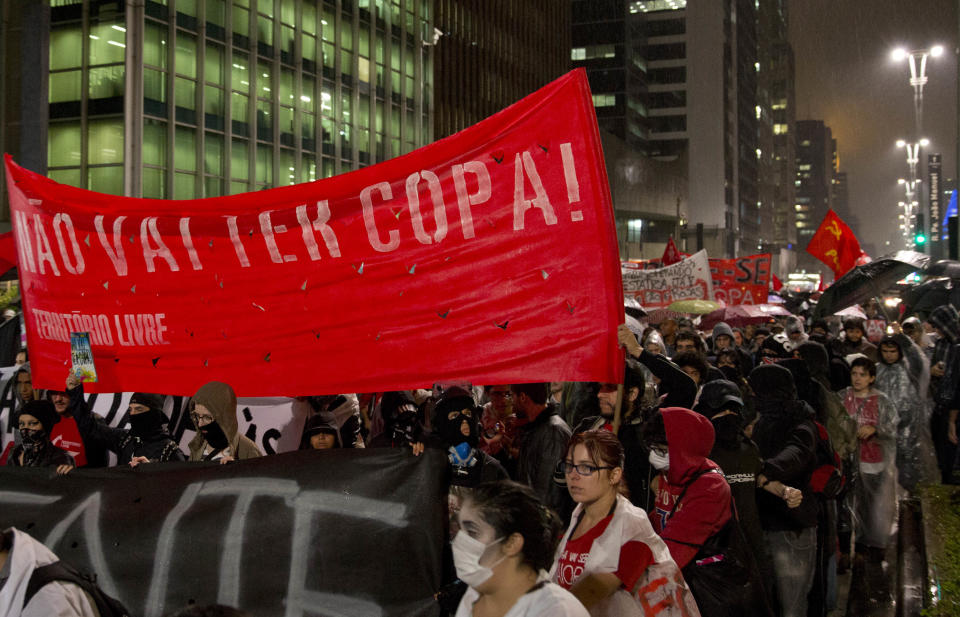 Demonstrators holding a banner that reads in Portuguese "There won't be a cup!" protest the amount of money spent on World Cup preparations in Sao Paulo, Brazil, Tuesday, April 15, 2014. Brazil will host the soccer tournament this year. (AP Photo/Andre Penner)