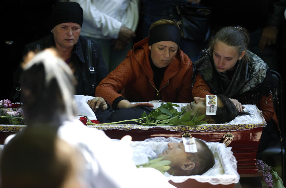 Relatives mourn in front of coffins of four people killed during clashes last week between Ukrainian and pre-Russian forces, during a commemoration service in the center of Slovyansk, eastern Ukraine, Wednesday, May 7, 2014. The U.S. and European nations have increased diplomatic efforts ahead of Ukraine's May 25 presidential election, as a pro-Russian insurgency continues to rock the country's eastern regions. (AP Photo/Darko Vojinovic)