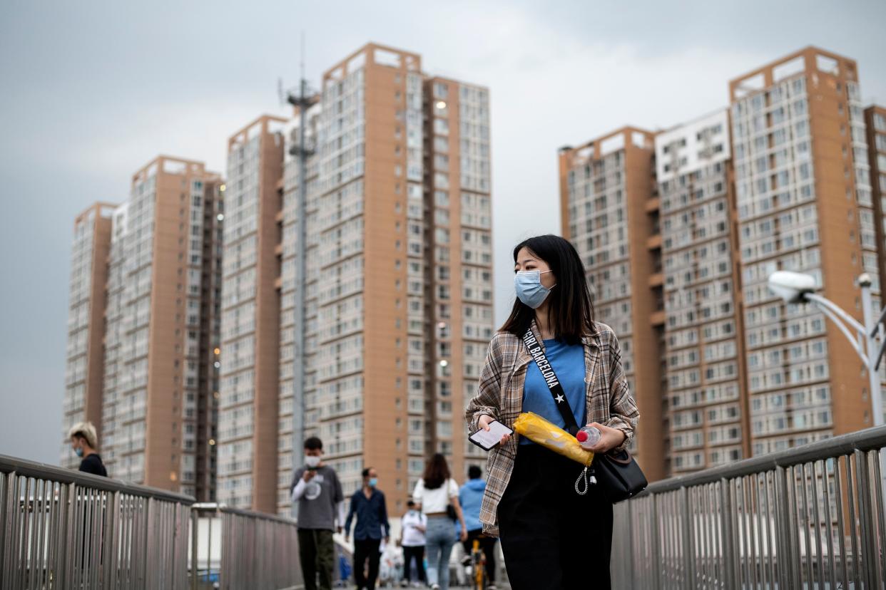 People wearing facemasks walk on an overpass in Beijing on June 1, 2020. (Photo by Noel CELIS / AFP) (Photo by NOEL CELIS/AFP via Getty Images)