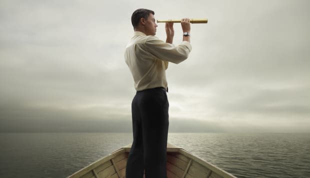 Man in boat looking through spyglass