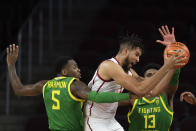 Southern California's Isaiah Mobley, center, is double-teamed by Oregon's De'Vion Harmon, left, and Quincy Guerrier during the first half of an NCAA college basketball game Saturday, Jan. 15, 2022, in Los Angeles. (AP Photo/Jae C. Hong)