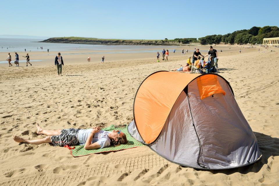 A man relaxes by his tent at Barry Island, Vale of Glamorgan, Wales. (PA)