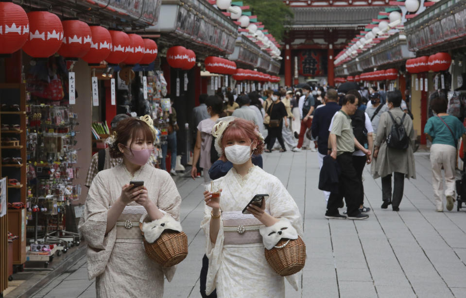 Japanese kimono-clad women wearing face masks to help protect against the spread of the coronavirus walk along the Asakusa area in Tokyo Wednesday, June 30, 2021. (AP Photo/Koji Sasahara)