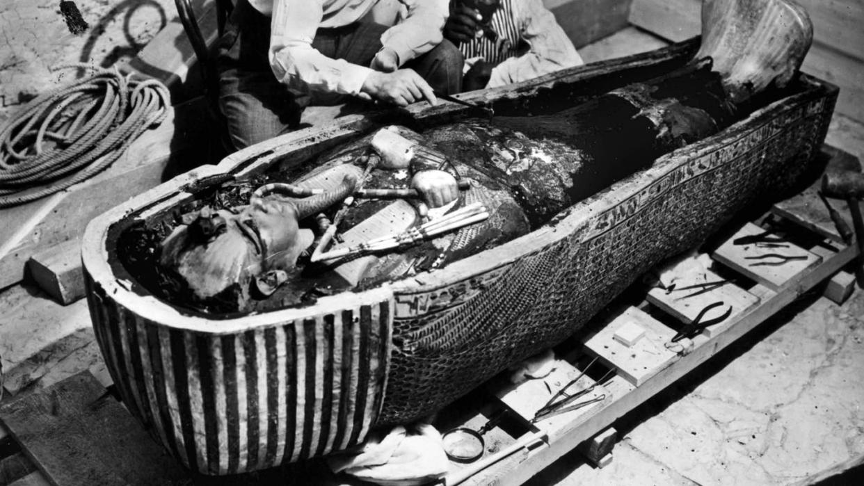 a couple of men working on a sarcophagus of king tut