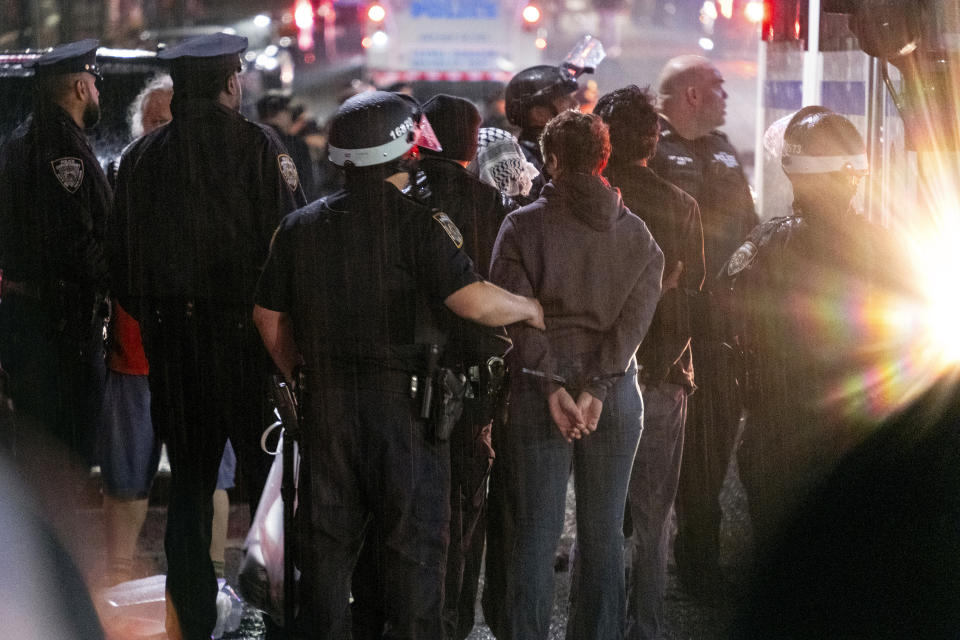 FILE - As light rain falls, New York City police officers take people into custody near the Columbia University campus in New York, Tuesday, April 30, 2024, after a building taken over by protesters earlier in the day was cleared, along with a tent encampment. (AP Photo/Craig Ruttle, File)
