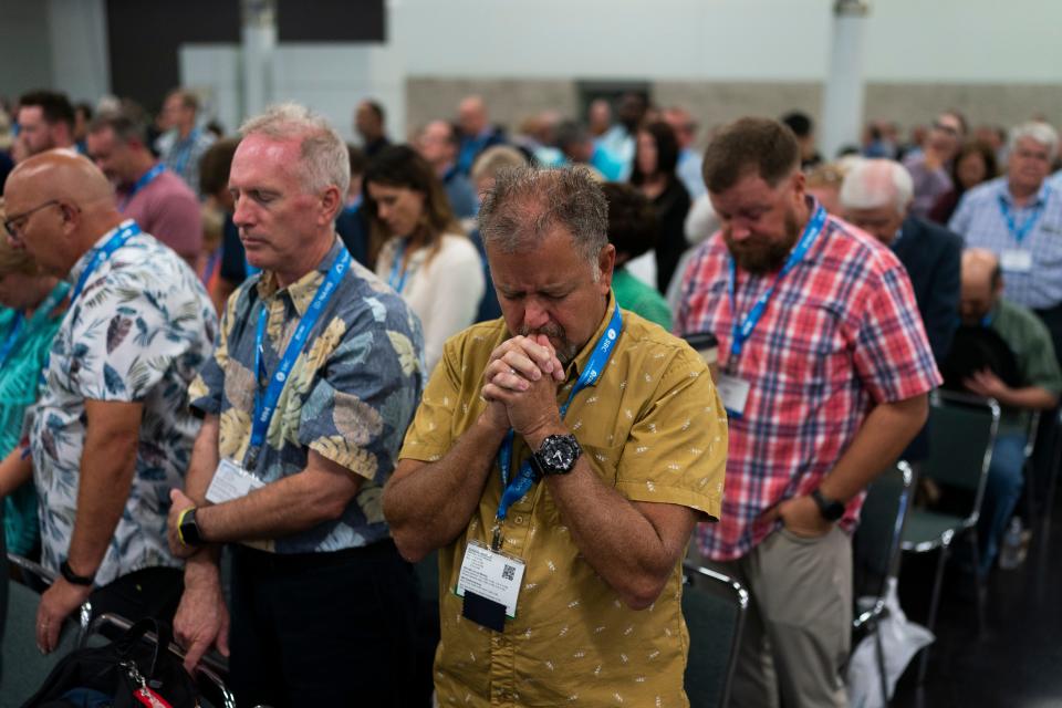 Attendees pray Tuesday during the Southern Baptist Convention's annual meeting in Anaheim, Calif.