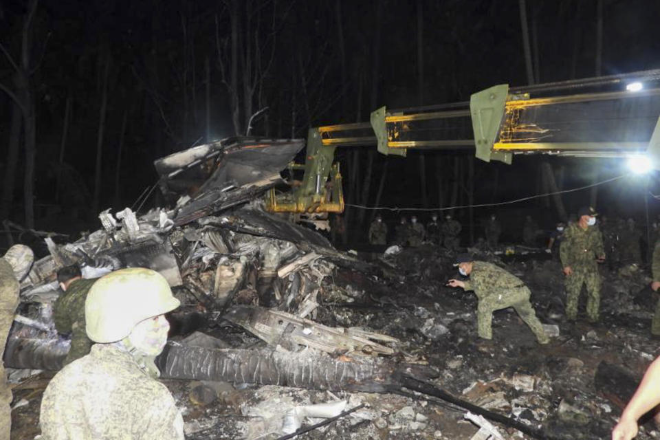 In this photo released by the Joint Task Force - Sulu, military soldiers search beside the remains of a Philippine military C-130 plane that crashed in Patikul town, Sulu province, southern Philippines, Sunday July 4, 2021. Philippine troops found the last five dead from the crash of the transport aircraft in the south, raising the death toll to 50 in the military's worst air disaster, officials said Monday. (Joint Task Force-Sulu via AP)