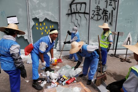 Workers clean up outside the Legislative Council, a day after protesters broke into the building in Hong Kong