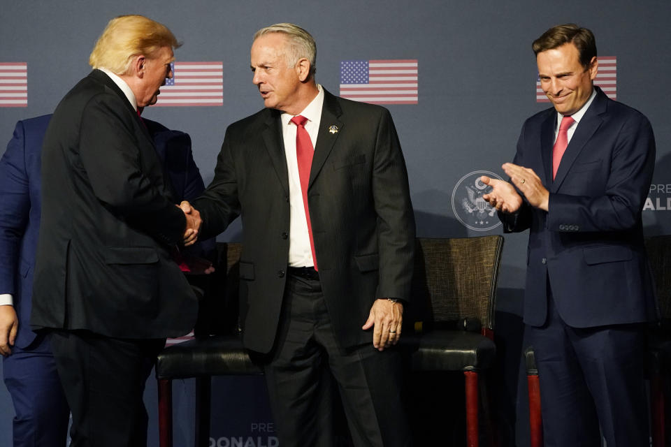 FILE - Former President Donald Trump, left, shakes hands with Joe Lombardo, Clark County sheriff and Republican candidate for Nevada governor, next to Republican Nevada Senate candidate Adam Laxalt, right, during an event Friday, July 8, 2022, in Las Vegas. Las Vegas-based hotel magnate and longtime UFO researcher Robert Bigelow has donated, through his owned companies, a total of $5.7 million to Lombardo’s campaign or PACs supporting his campaign this election cycle. (AP Photo/John Locher, File)