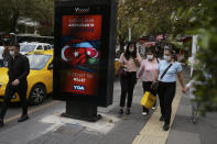 FILE - In this Oct. 8, 2020, people wearing masks to protect against the spread of coronavirus, walk past a billboard that reads "Turkey and Azerbaijan, two states one nation" in Ankara, Turkey. Unlike previous outbursts of hostilities over the separatist region of Nagorno-Karabakh, NATO-member Turkey, which has close ethnic, cultural and historic bonds with Azerbaijan, took a higher profile and vowed to help Azerbaijan reclaim its territory. (AP Photo/Burhan Ozbilici, File)