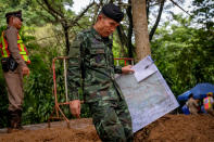 <p>An officer carring a map walks out of Tham Luang Nang Non Cave on June 30, 2018, in Chiang Rai Province, Thailand. U.S. forces and British divers joined the search for the soccer team, aged between 11 to 16, and their their 25-year-old coach. (Photo: Linh Pham/Getty Images) </p>