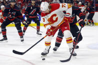 Calgary Flames' Tyler Toffoli (73) controls the puck in front of Carolina Hurricanes' Brent Burns (8) during the first period of an NHL hockey game in Raleigh, N.C., Saturday, Nov. 26, 2022. (AP Photo/Karl B DeBlaker)