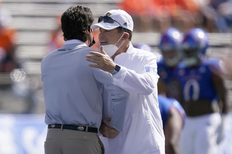 Oklahoma State head coach Mike Gundy, left, and Kansas head coach Les Miles talk before an NCAA college football game in Lawrence, Kan., Saturday, Oct. 3, 2020. (AP Photo/Orlin Wagner)